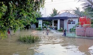Anak-anak bermain air di halaman rumah warga yang kebanjiran